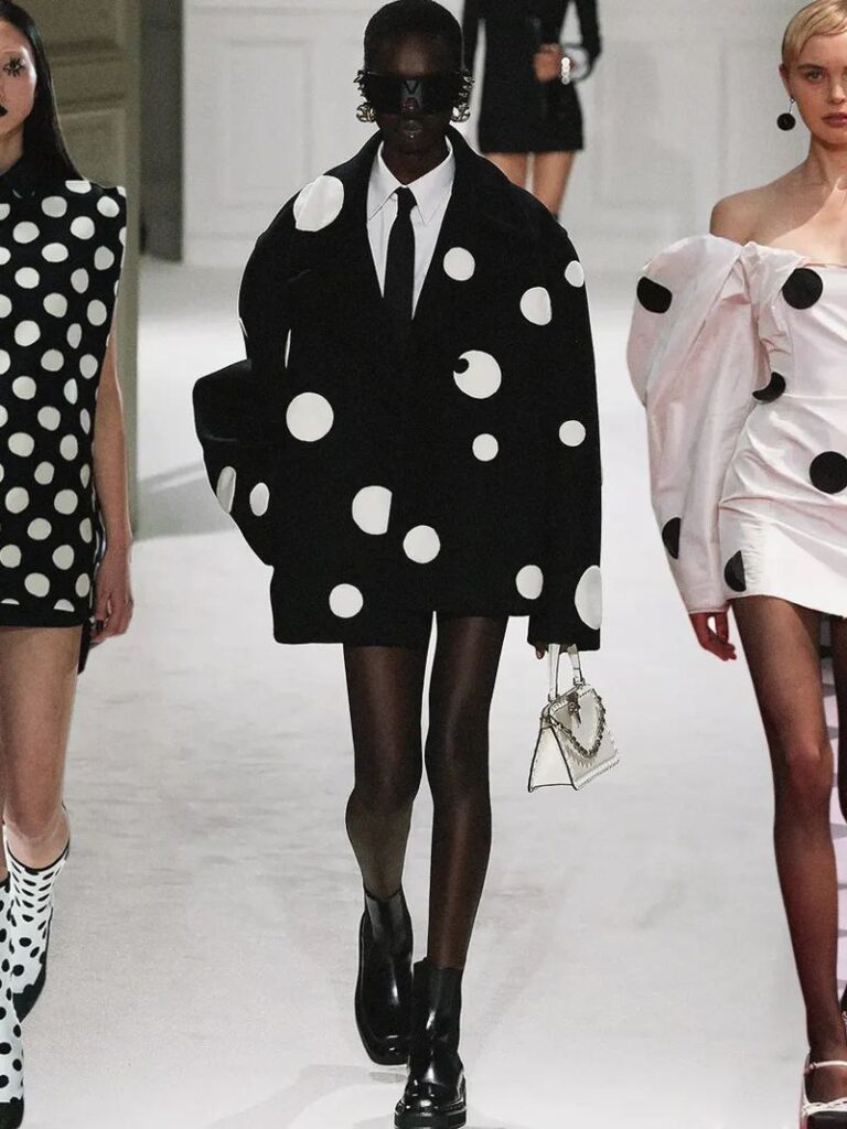 Photo du défilé de Valentino automne/hiver 2023-2024, une femme vêtue d'un énorme blazer noir à pois 