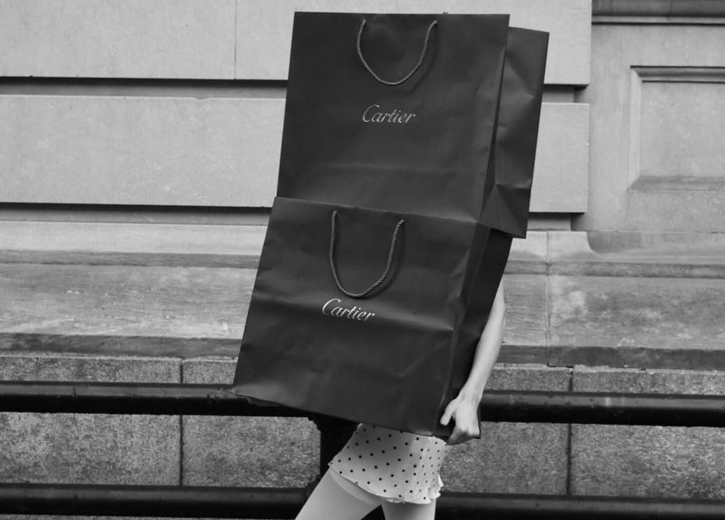 Une femme qui tient deux gros sacs cartier, photo en noir et blanc 